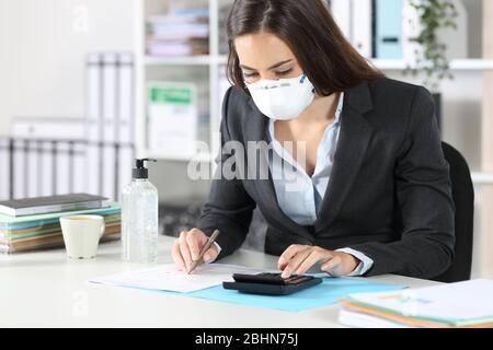 Buchhalter mit Schutzmaske Berechnen mit Rechner abhaken Dokument im Büro Stockfoto