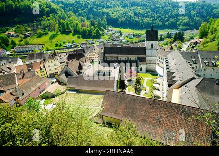 Luftaufnahme der Stiftskirche Saint Ursanne und ihres Kreuzganges in der charmanten mittelalterlichen Stadt Saint Ursanne, Kanton Jura, Schweiz. Stockfoto