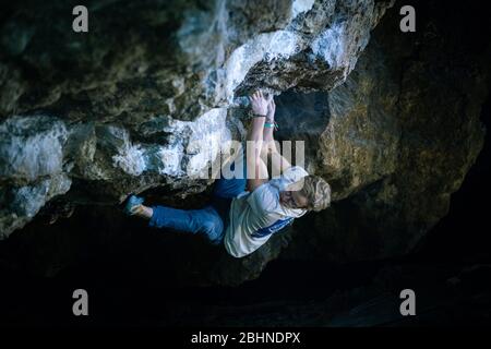 Der Mensch macht einen Felsbrocken in der Twardowski Höhle. Bouldern im Fels. Twardowski Höhle Stockfoto