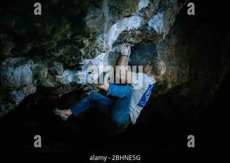 Der Mensch macht einen Felsbrocken in der Twardowski Höhle. Bouldern im Fels. Twardowski Höhle Stockfoto