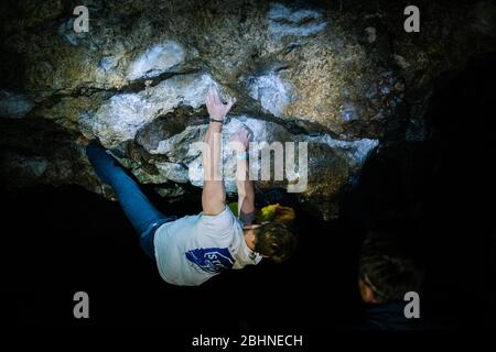 Der Mensch macht einen Felsbrocken in der Twardowski Höhle. Bouldern im Fels. Twardowski Höhle Stockfoto