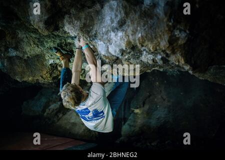 Der Mensch macht einen Felsbrocken in der Twardowski Höhle. Bouldern im Fels. Twardowski Höhle Stockfoto