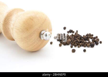 Pfeffermühle aus Holz mit Pfefferkörnern und gemahlener Pfeffer Stockfoto