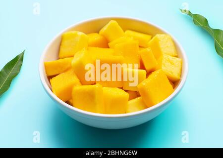 Tropische Früchte, Mango Würfel Scheiben in weißer Schüssel auf blauem Hintergrund. Stockfoto