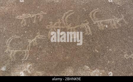 Alte Petroglyphen von Jägern und Ibex bei Langar auf Felsen und Berg im Wakhan-Korridor in Tadschikistan. Stockfoto