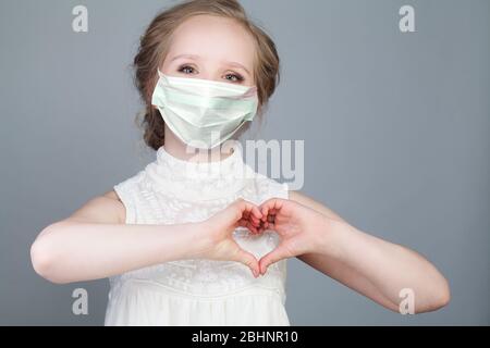 Junge Frau in medizinischen Maske Herz, hängen zusammen Stockfoto