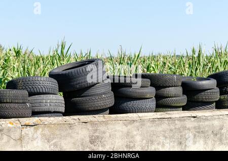 Gebrauchte alte Reifen an Betonwand in der Nähe eines Bauernhofes in Rheinland-Pfalz, Deutschland, Westeuropa Stockfoto