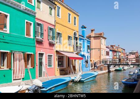 Burano Island, Venedig, Italien. Fondamenta di Cavanella mit bunten Häusern entlang des Kanals und Touristen Sightseeing im Zentrum des Dorfes Stockfoto