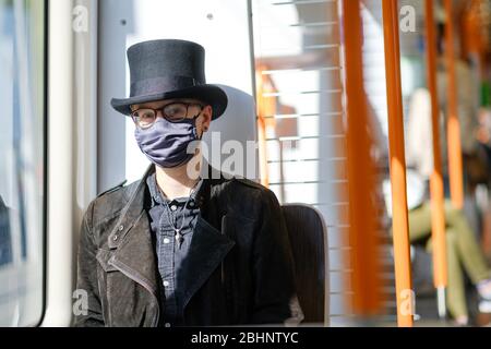 Hannover, Deutschland. April 2020. Kris trägt eine Gesichtsmaske und einen Zylinder in der Straßenbahn. Seit Montag sind in Niedersachsen Masken für öffentliche Verkehrsmittel und Geschäfte Pflicht. Kredit: Ole Spata/dpa/Alamy Live News Stockfoto