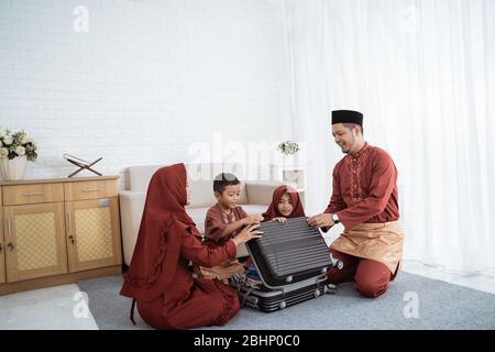 Asiatische Familie bereiten Kleidung und legte in einem Koffer, um Mudik in die Heimatstadt gebracht werden Stockfoto