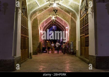 Buchara, Usbekistan - 7. Juni 2019: Abend mit Menschen in der Altstadt von Buchara in der Nähe des Devonbegi Teiches und der Bozori-Kord-Moschee in Usbekistan. Stockfoto