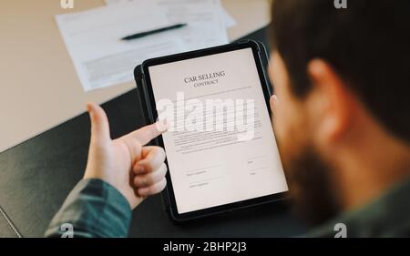 Mann zeigt Auto-Verkauf Vertrag auf Tablet und zeigt Daumen nach oben. Stockfoto