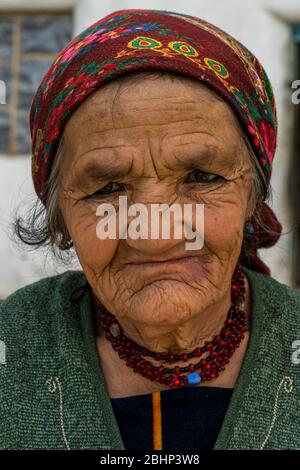 Wakhan, Tadschikistan - 20. Juni 2020: Porträt einer alten Frau in traditioneller Kleidung im Wakhan-Tal an der Pamir-Autobahn in Tadschikistan. Stockfoto