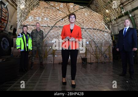 27. April 2020, Sachsen, Schkeuditz: Bundesverteidigungsministerin Annegret Kramp-Karrenbauer (CDU) steht in einer Antonov am Flughafen Leipzig/Halle vor einem Bundeswehrtransport mit Schutzmasken. Die Masken waren zuvor mit dem weltweit größten Frachtflugzeug Antonov 225 am Flughafen gelandet. Die "Airlift" aus China besteht nach Angaben der Bundeswehr aus insgesamt drei Frachtflügen. Rund 25 Millionen Schutzmasken sollen nach Deutschland geflogen werden. Der Transport ist Teil der administrativen Unterstützung der Bundeswehr in der Corona-Krise. Foto: Hendrik Schmidt/dp Stockfoto