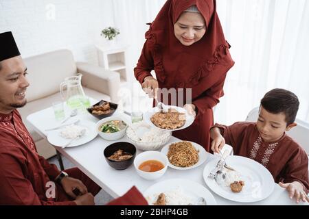 Muslimische Familie essen gerne, wenn das Fasten zu Hause gemeinsam bricht Stockfoto