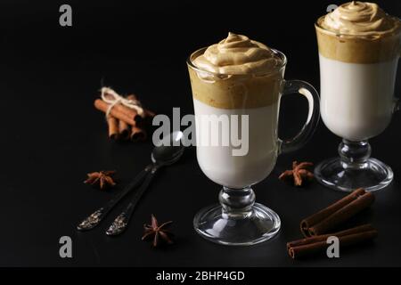 Dalgona cremiger Kaffee in zwei Gläsern auf schwarzem Hintergrund mit Schlagschaum. Koreanischer Kaffee Trend, Horizontales Format, Raum für Text. Stockfoto