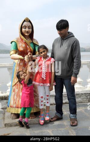 Nathdwara, Rajasthan, Indien, Asien - 23. Januar 2014 - Indischer Familienvater mit zwei kleinen niedlichen Mädchen, die im Park mit Frau Statue spielen Stockfoto