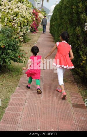 Nathdwara, Rajasthan, Indien, Asien - Jan. 23, 2014 -Indische glücklich zwei kleine süße Mädchen zu Fuß im Park Stockfoto