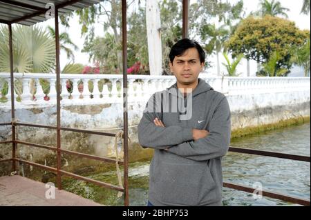 Nathdwara, Rajasthan, Indien, Asien - 23. Januar 2014 - Indischer junger Mann, der lächelnd im Park steht Stockfoto