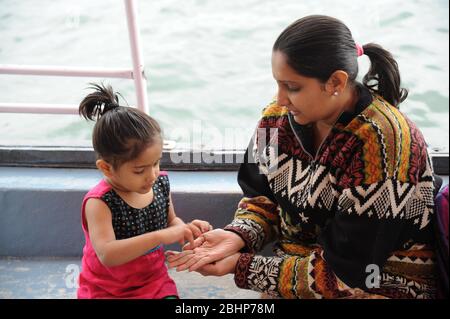 Nathdwara, Rajasthan, Indien, Asien - 23. Januar 2014 - Indische Mutter und Kind spielen im Boot Stockfoto