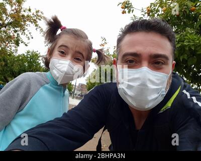 Vater und Tochter tragen FFP2 und N95 Masken auf der Straße. Stockfoto