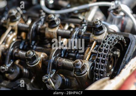 Ein detaillierter Aufnahme des Zylinderkopfes eines Vergasermotors. Viertakt-Benzinmotor ohne Abdeckung. Gasverteilungs-Mechanismus und Kettennahaufnahme. Stockfoto
