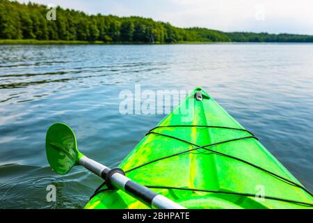 Schöne Naturlandschaft am See mit grünem Kajak. Kajakfahren auf einem See. Stockfoto