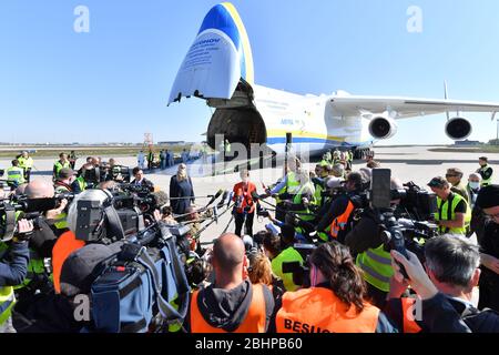 27. April 2020, Sachsen, Schkeuditz: Bundesverteidigungsministerin Annegret Kramp-Karrenbauer (CDU, M.) steht auf dem Flughafen Leipzig/Halle umgeben von Pressevertretern vor einem Wehrmachtstransport mit Schutzmasken in einer Antonow. Die Masken waren zuvor mit dem weltweit größten Frachtflugzeug, der Antonov 225, am Flughafen gelandet. Die "Airlift" aus China besteht nach Angaben der Bundeswehr aus insgesamt drei Frachtflügen. Rund 25 Millionen Schutzmasken sollen nach Deutschland geflogen werden. Der Transport ist Teil der Verwaltungshilfe der Bundeswehr im Stockfoto