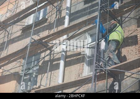 Arbeiter auf Gerüsten auf dem Gebäude in der Stadt Stockfoto