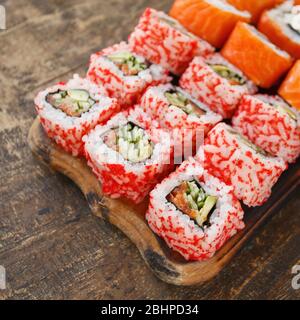 Zwei verschiedene Arten von Sushi-Rollen auf einem Holzbrett. Japanische Küche Stockfoto