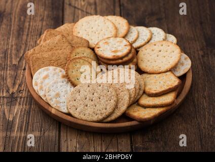 Verschiedene Biokrispige Weizen-, Roggen- und Mais-Fladenbrot-Cracker mit Sesam und Salz in runder Platte auf Holzhintergrund. Stockfoto