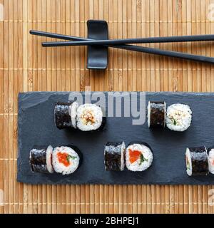 Maki Sushi mit Thunfisch, Lachs und Avocado. Nori draußen. Stockfoto