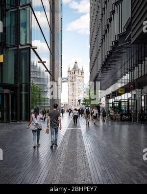 Mehr London Riverside, England. Touristen und Büroangestellte im neuen Geschäfts- und Einzelhandelsbereich in der Nähe der Tower Bridge und der Wahrzeichen der City Hall, Großbritannien. Stockfoto