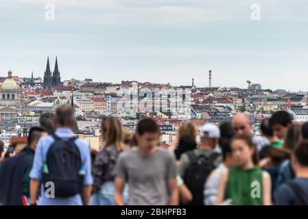 Menschen, Touristen beobachten Stadtbild von Prag an sonnigen Tag. Die Detailansicht des modernen und alten Stadtteils mit traditionellen roten Dächern. Stockfoto