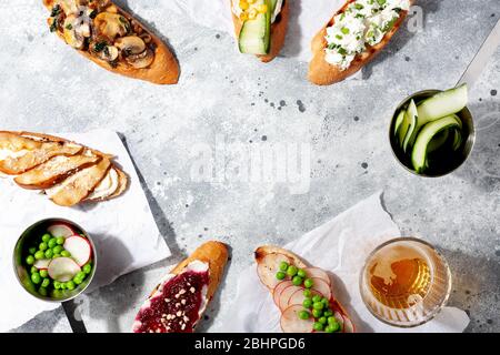 Verschiedene italienische Vorspeise Bruschetta oder Tapas-Set mit verschiedenen herzhaften und süßen Belag auf grauen Beton background.Top view, kopieren Raum Stockfoto