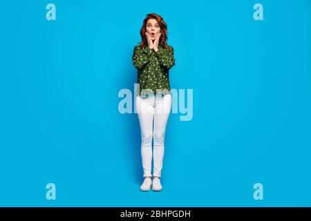 In voller Länge Foto von ziemlich funky verrückte Dame Hände auf Wangen hören gute Nachrichten starren offenen Mund tragen grün gepunktete Hemd weiß Hose Schuhe isoliert Stockfoto