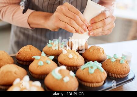 Unkenntlich Bäcker stehen Dekoration frisch hausgemachte Cupcakes mit süßen Sahne, horizontale Nahaufnahme Stockfoto