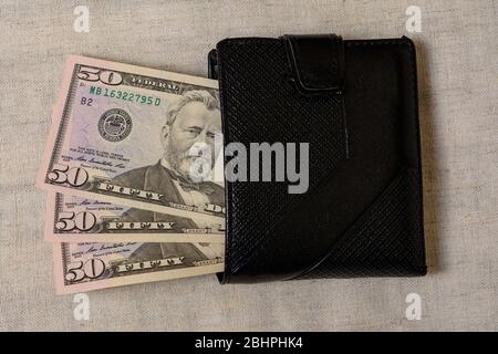 Schwarze Brieftasche mit 50 Dollar auf grauem Hintergrund.2020 Stockfoto
