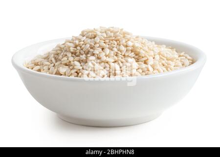 Geschälte Sesamsamen in einer weißen Keramikschale, die auf Weiß isoliert ist. Niedriger Winkel. Stockfoto