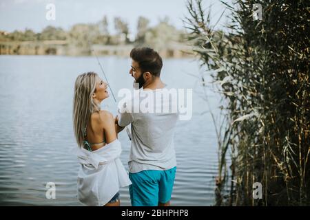 Schönes junges Paar genießen Angeln auf dem See an sonnigen Sommertag Stockfoto
