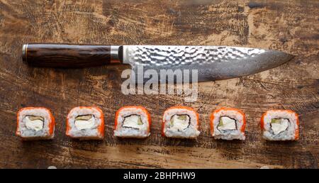 Schöne Philadelphia Sushi-Rollen mit Lachs und Frischkäse und Gurke auf Holzhintergrund. Stockfoto
