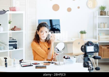 Junge Erwachsene kaukasische Frau tun Casual Make-up und Aufnahmeprozess vor der Kamera Stockfoto