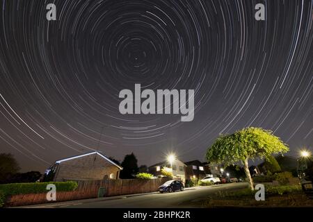 Star Trails im Northern Sky über eine Wohnsiedlung in Worcestershire, Großbritannien. Bild verrückt mit Zeitaufnahme. Stockfoto