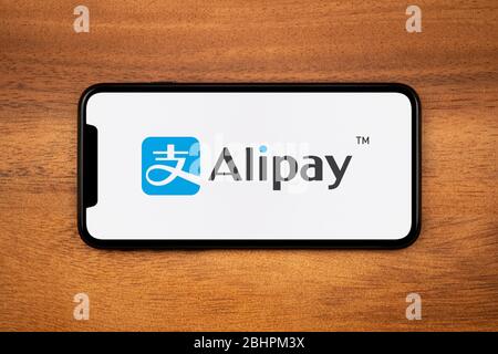 Ein Smartphone mit dem Alipay-Logo liegt auf einem einfachen Holztisch (nur für redaktionelle Zwecke). Stockfoto