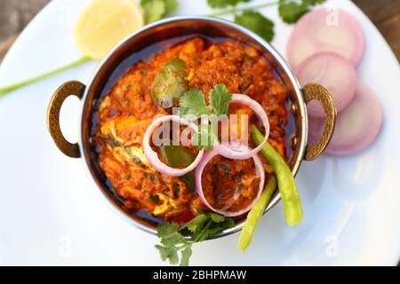 HÜTTENKÄSE IM INDISCHEN STIL VEGETARISCHES CURRY GERICHT. Kadai Paneer – traditionelle indische oder punjabi-Küche. Garniert mit Zwiebel- und Chilischeiben. Stockfoto