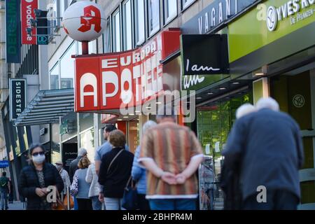 Hannover, Deutschland. April 2020. Passanten stehen vor einer Apotheke im Stadtzentrum Schlange. Seit Montag sind in Niedersachsen Masken für öffentliche Verkehrsmittel und Geschäfte Pflicht. Kredit: Ole Spata/dpa/Alamy Live News Stockfoto