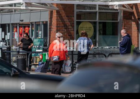 Die Käufer im Gallagher Retail Park stehen während der landesweiten Sperrung des Coronavirus vor langen Warteschlangen vor M&S und B&M. Stockfoto