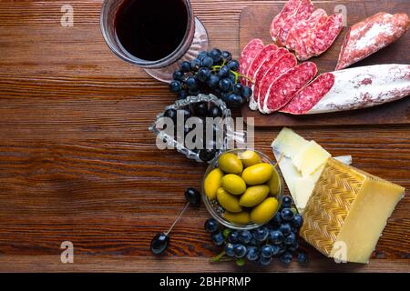 Sorte Essen auf dem Tisch, Rotwein, Käse und Aufschnitt Salami, Oliven Mix in Glasschalen, kalten Tapas für mediterranes Menü, Snackbar Stockfoto