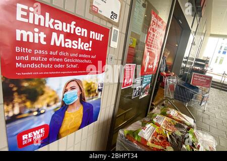 Lockerung und Maskierung der Coronavirus-Pandemie: Geschäfte in Bayern werden am 27. April wieder eröffnet. Ein Schild zeigt das Tragen von Mund, Nasenschutz. REWE Supermarkt, Filiale, Eingang, Nutzung weltweit Stockfoto