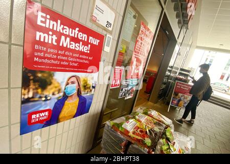 Lockerung und Maskierung der Coronavirus-Pandemie: Geschäfte in Bayern werden am 27. April wieder eröffnet. Ein Schild zeigt das Tragen von Mund, Nasenschutz. REWE Supermarkt, Filiale, Eingang, Nutzung weltweit Stockfoto